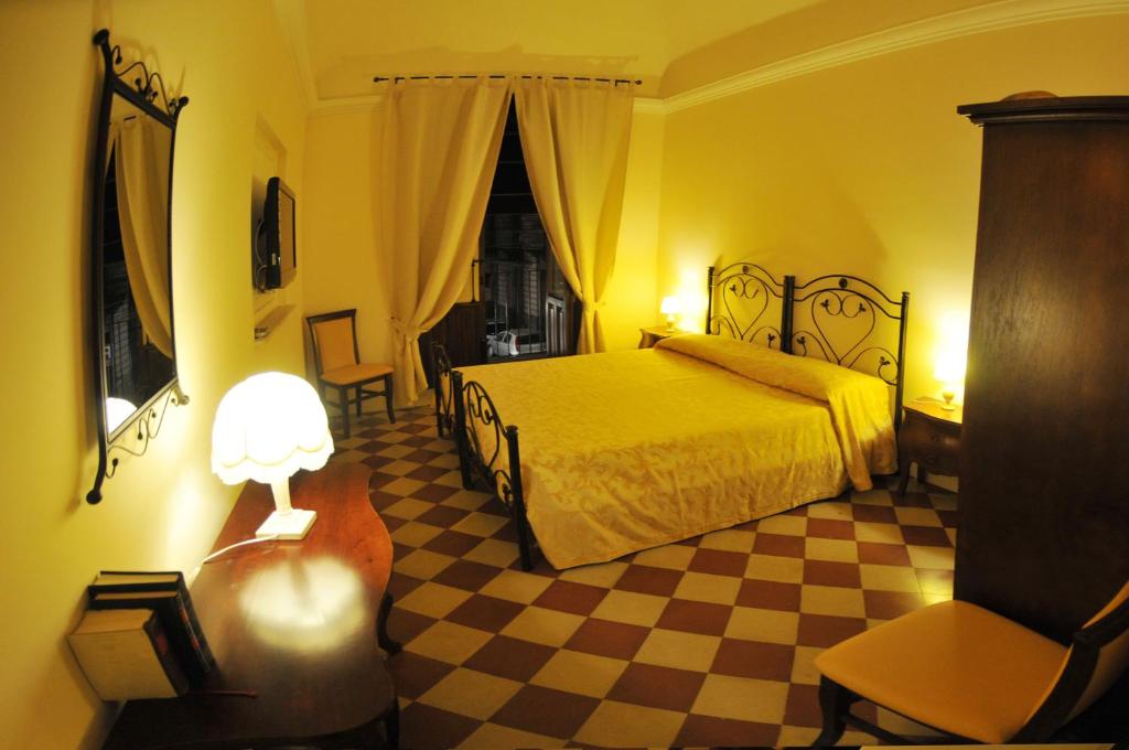 a bedroom with a bed and a checkered floor at Al Duomo Inn in Catania