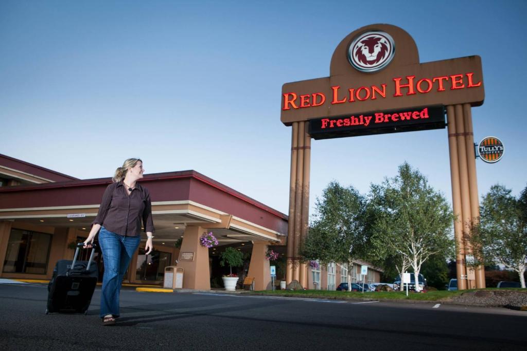 a woman walking in front of a red lion hotel at Red Lion Hotel Kelso in Kelso