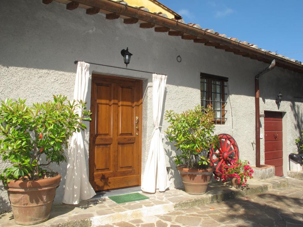 une maison avec une porte en bois et des plantes en pot dans l'établissement Casavacanze I PINI, à Cerbaia
