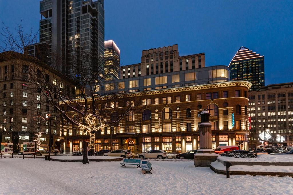 un edificio en una ciudad cubierta de nieve en Hôtel Birks Montréal, en Montreal