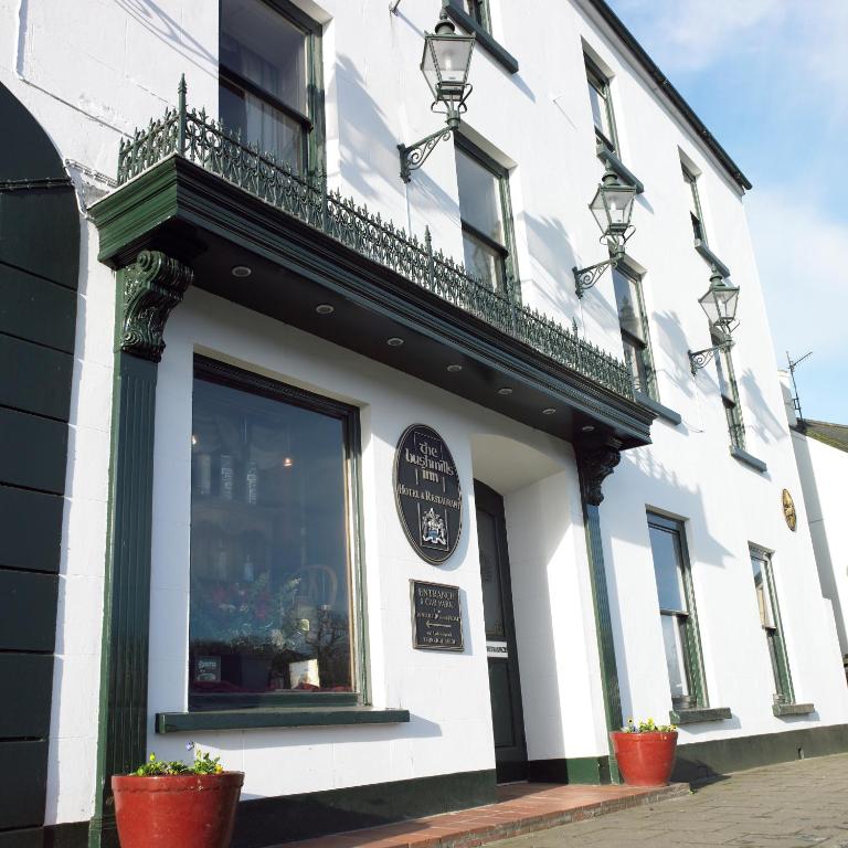 a white building with a balcony on top of it at Bushmills Inn Hotel & Restaurant in Bushmills