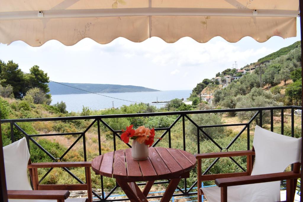 a table with a vase of flowers on a balcony at NIKIS ROOMS in Kalamakia