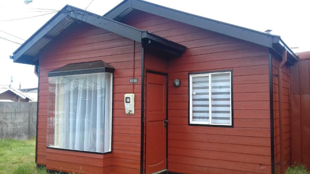 una casa roja con una ventana y una puerta en Casa Turismo Puerto Montt, en Puerto Montt