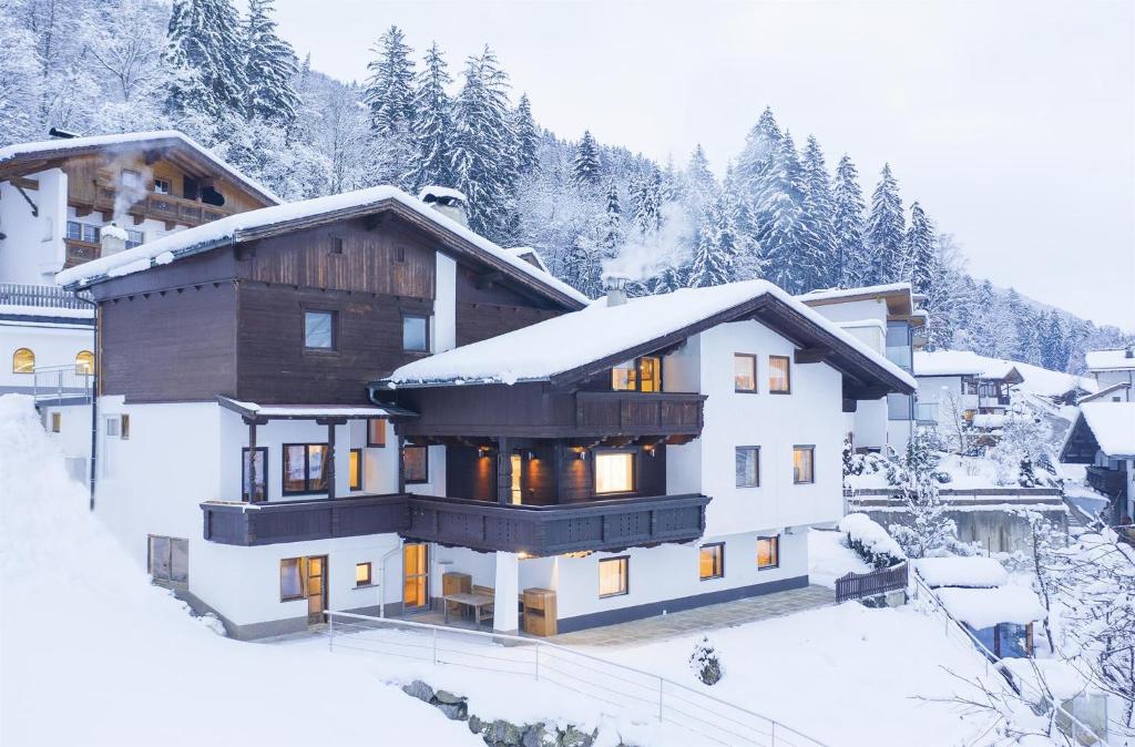 a house in the snow with snow covered trees at Apart Sunnseitn in Bruck am Ziller