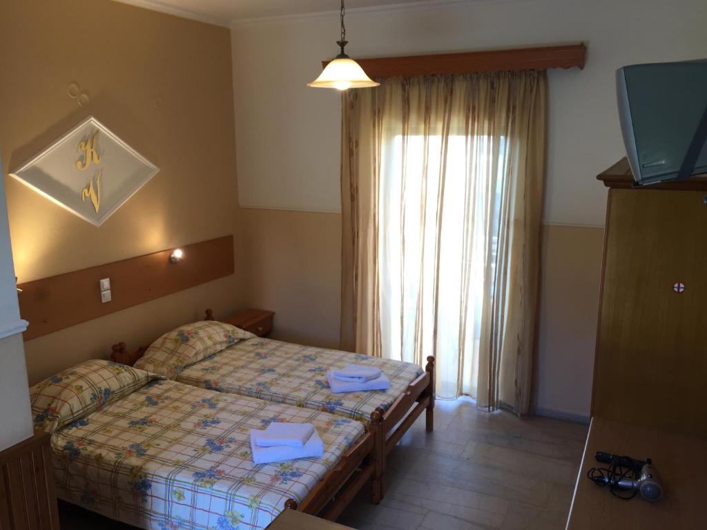 a small bedroom with a bed and a window at Eleni Apartments in Arillas