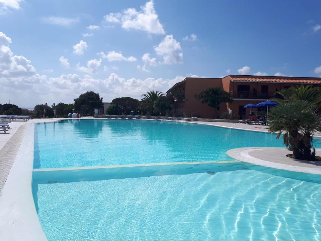 a large swimming pool with blue water at Casa Fabio in Stintino
