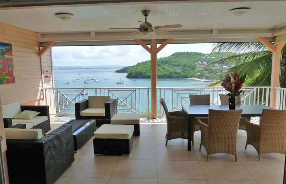 balcón con mesa, sillas y vistas al océano en Ti ' Plage, en Les Trois-Îlets