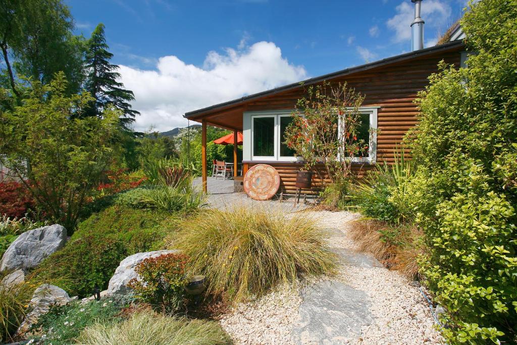a log cabin with a window and a patio at Joya Garden & Villa Studios in Nelson
