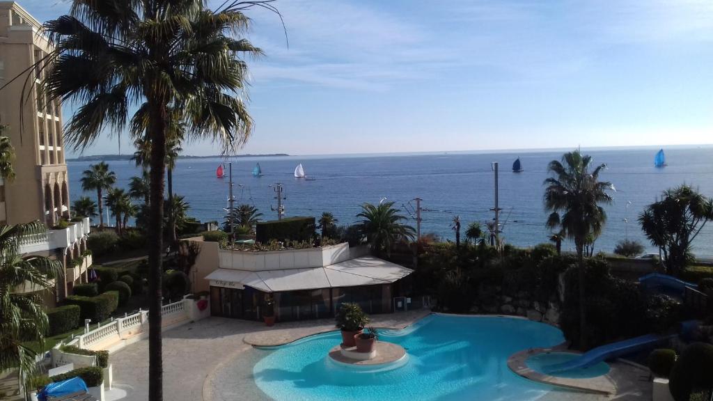 カンヌにあるAppartement Palm d'Azurのスイミングプールと海の景色を望めます。