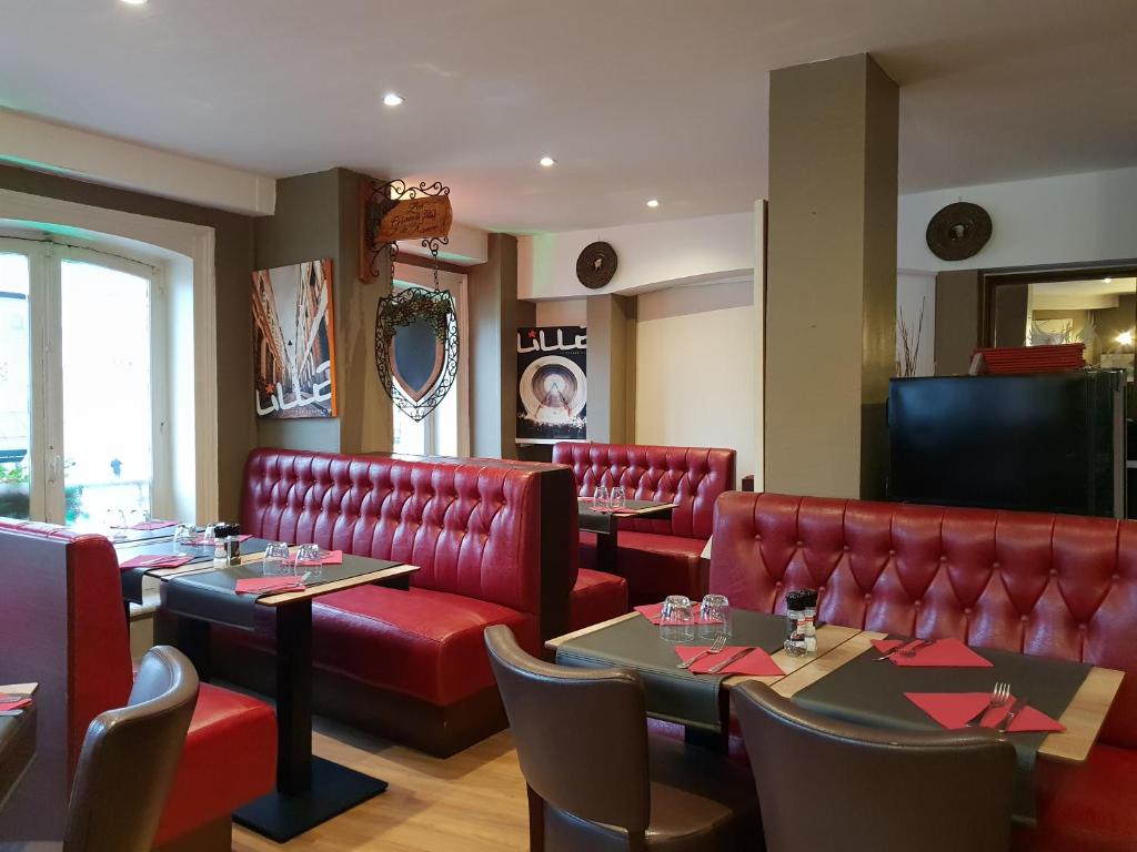 a restaurant with tables, chairs, and a red wall at Le Napoleon in Lille