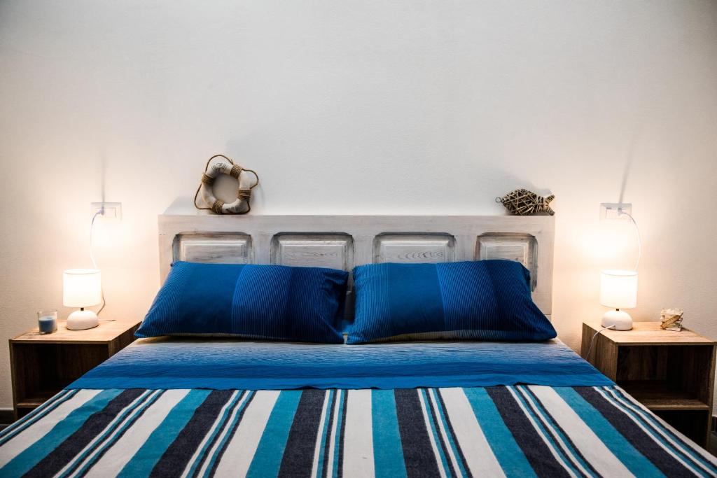 um quarto com uma cama azul com duas mesas de cabeceira em Mediterranean house em SantʼAntìoco