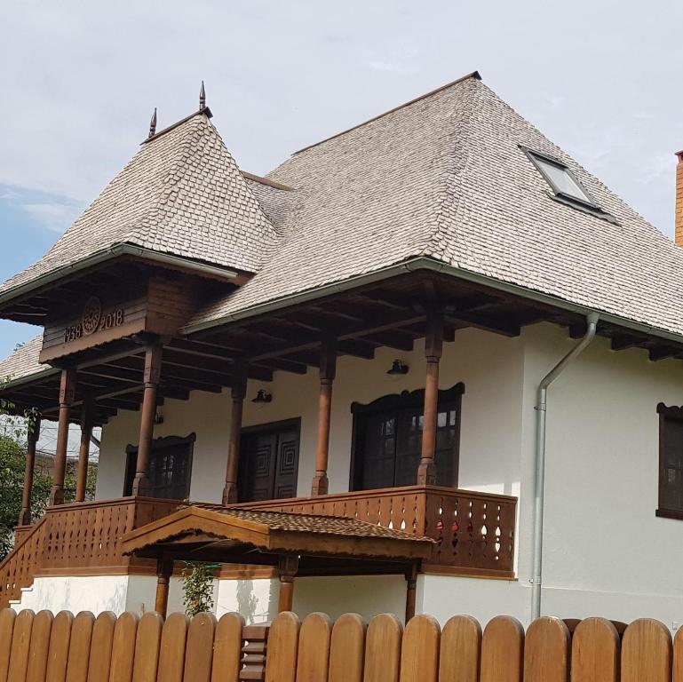 ein Haus mit einem Balkon mit einem Holzzaun in der Unterkunft Casa Tanti Patrita in Slon