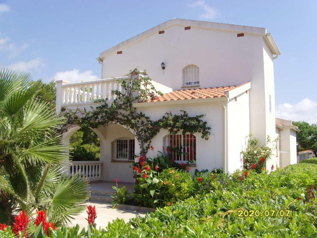 een wit huis met een balkon en bloemen bij RIVIERA in L'Ametlla de Mar