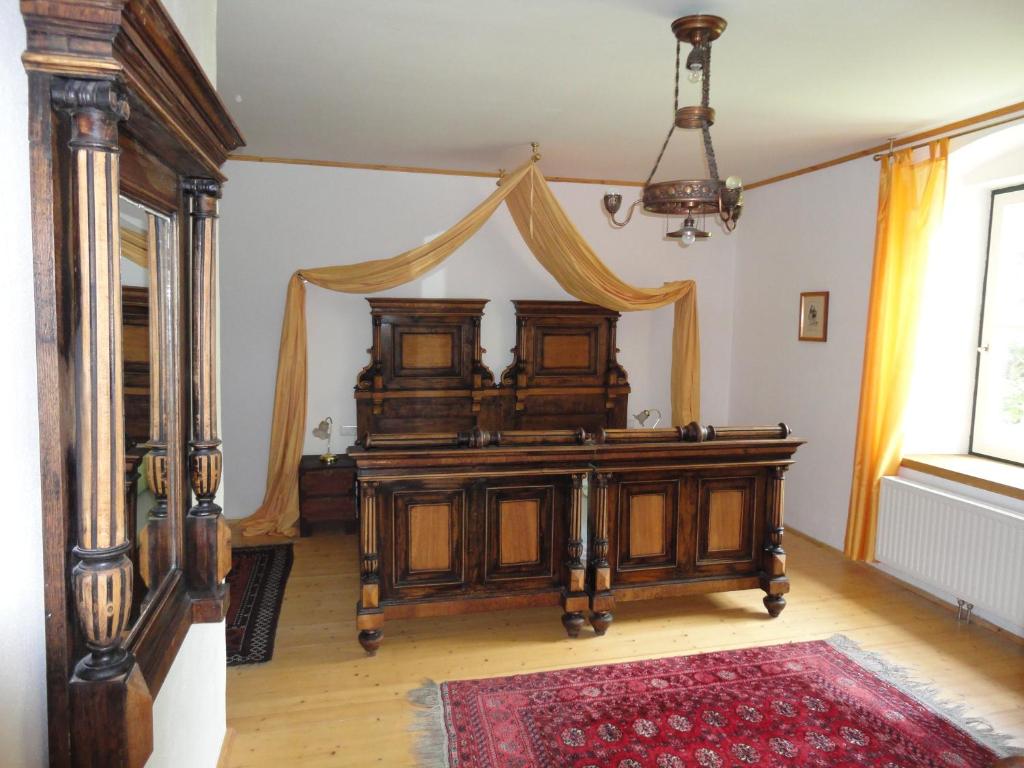Schlafzimmer mit einem Holzbett mit Baldachin in der Unterkunft Lindenhof in Murau