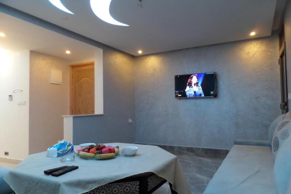 Habitación con mesa y TV en la pared. en Studio deluxe in Agadir en Agadir
