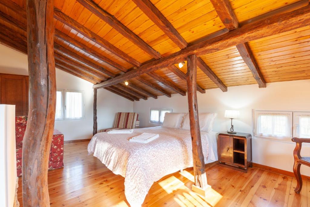 een slaapkamer met een bed en een houten plafond bij Loft Caminha in Caminha