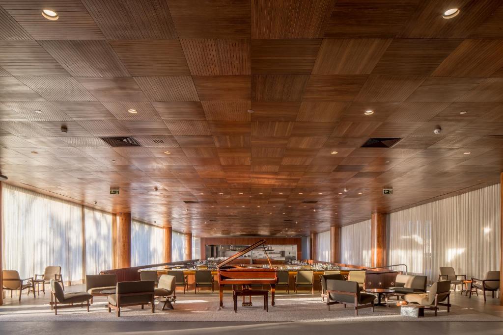 a lobby with chairs and tables and a piano at B Hotel Brasilia in Brasília