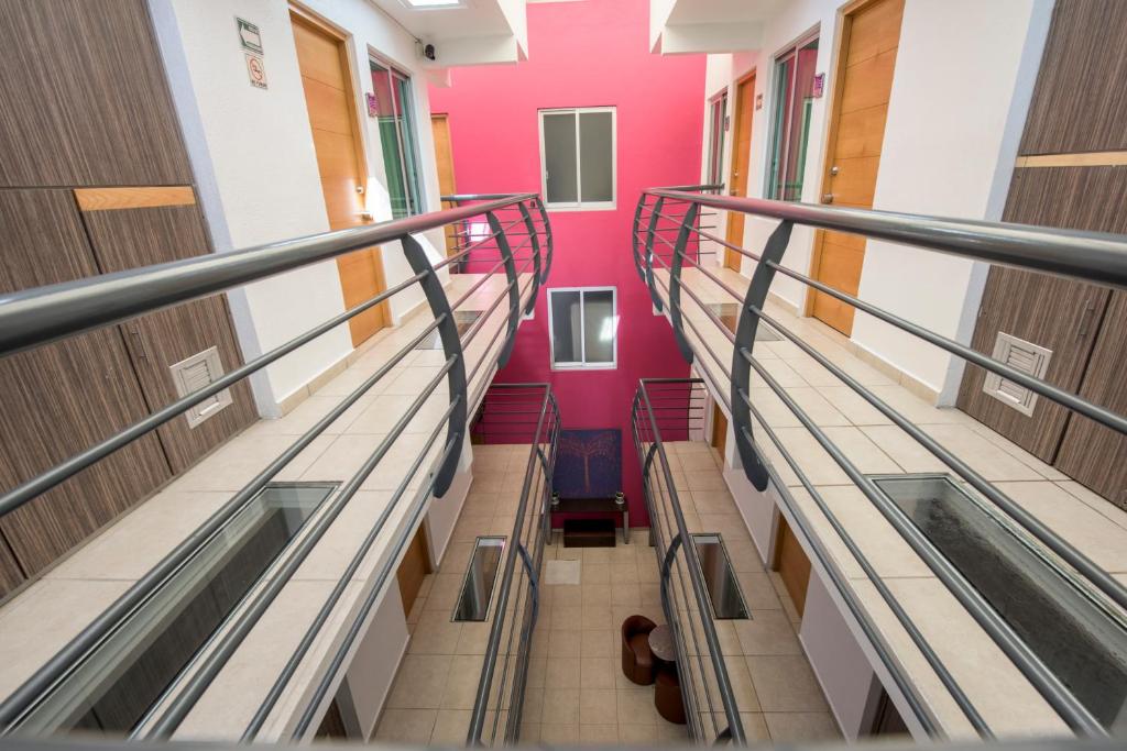 an empty hallway in a school building with pink walls at Hotel Oaxaca Inn Express in Oaxaca City