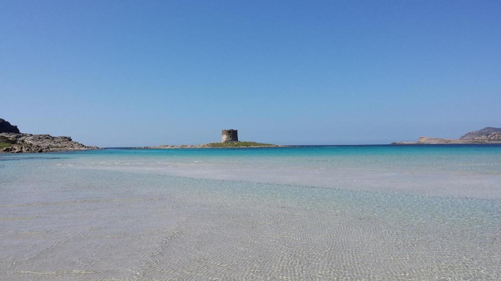 una playa con un faro en una isla en el agua en B&B Diana's en Stintino