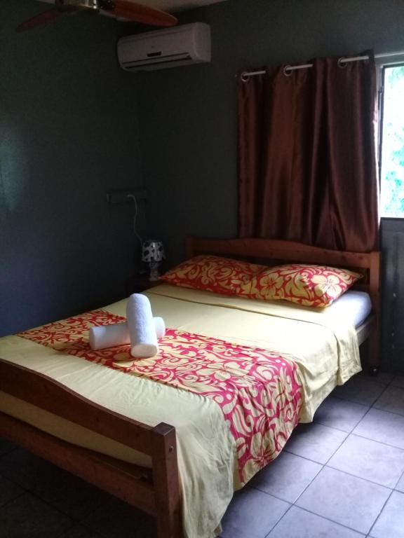 Raihei Location maison d'hôtes في بورا بورا: غرفة نوم بسريرين و دبدوب على السرير