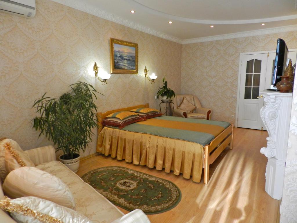 a bedroom with a bed and a couch at Ap-Rent Osokorky Apartments in Kyiv