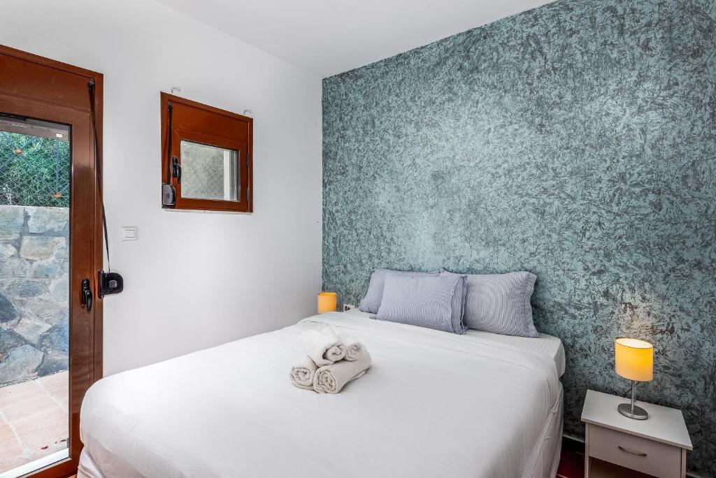 a bedroom with a white bed and a blue wall at Southern Dreams Apartments in Gennadi