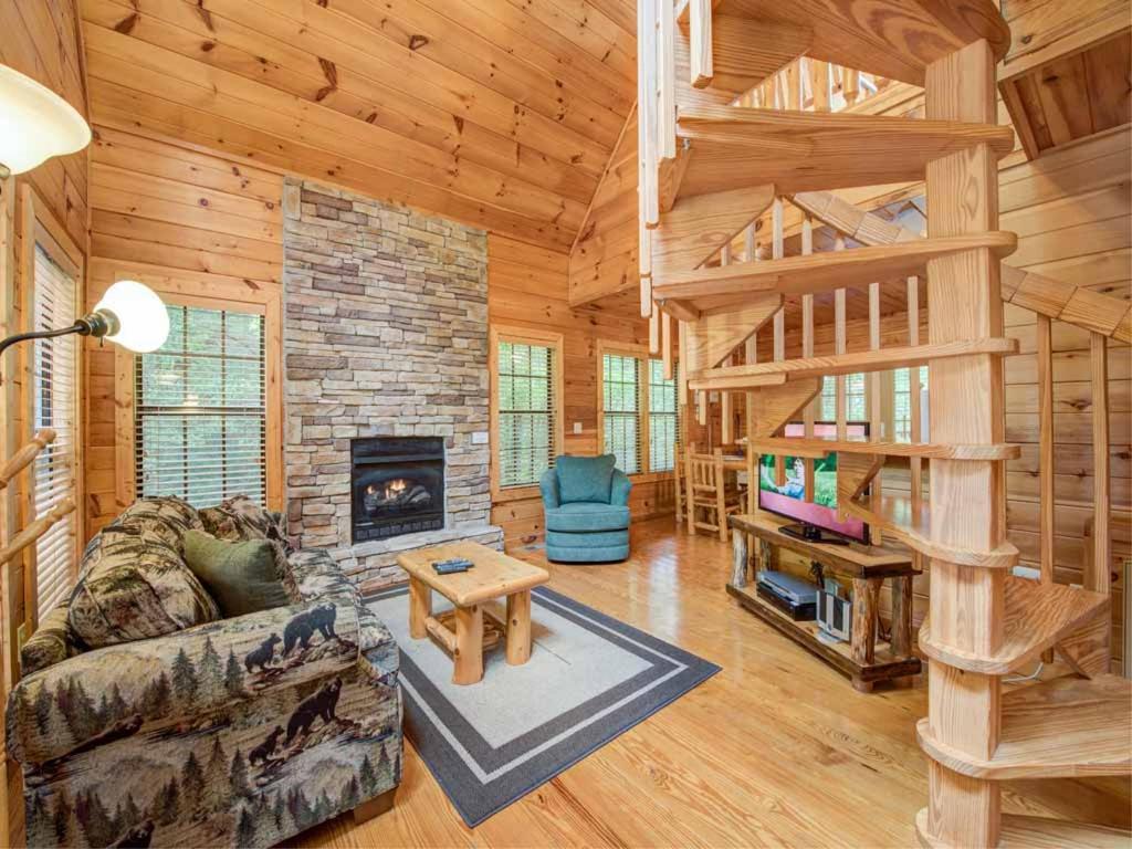 una sala de estar con una escalera en una cabaña de madera en A Walk in the Clouds, 1 Bedroom, Sleeps 4, Pool Table, Hot Tub, Pets, en Gatlinburg