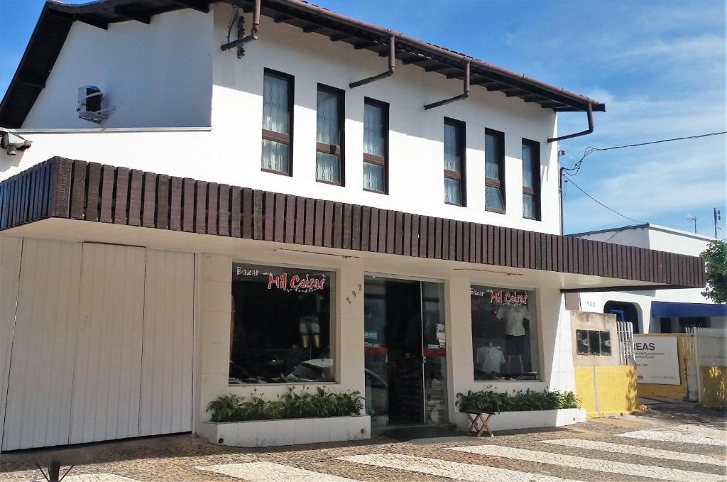 a store front of a white building with windows at Casa Santana do Paraíso in Bonito