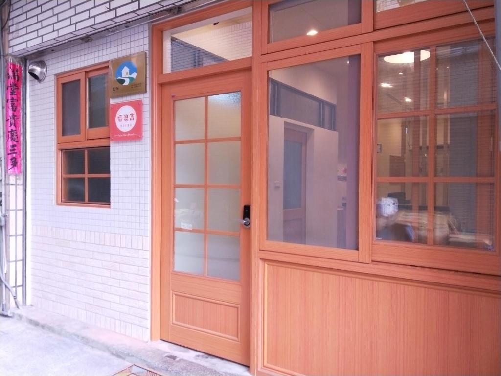 una puerta naranja en un edificio blanco en Fuaowo Backpackers Homestay, en Nangan