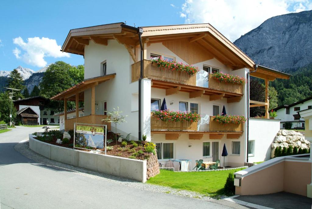 un bâtiment avec des boîtes de fleurs sur ses balcons dans l'établissement Appartements 4 Jahreszeiten, à Ehrwald