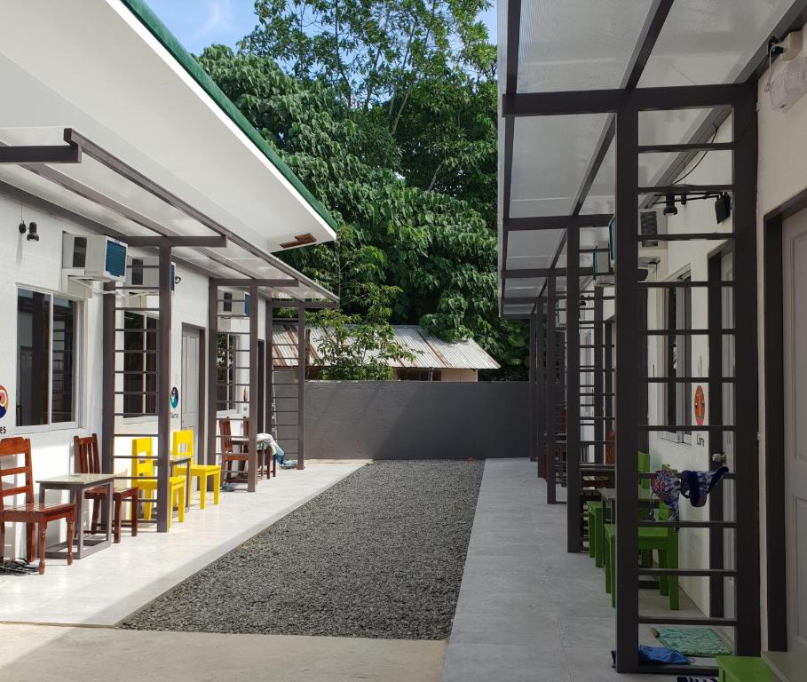 a building with a patio with tables and chairs at Inngo Tourist Inn in El Nido