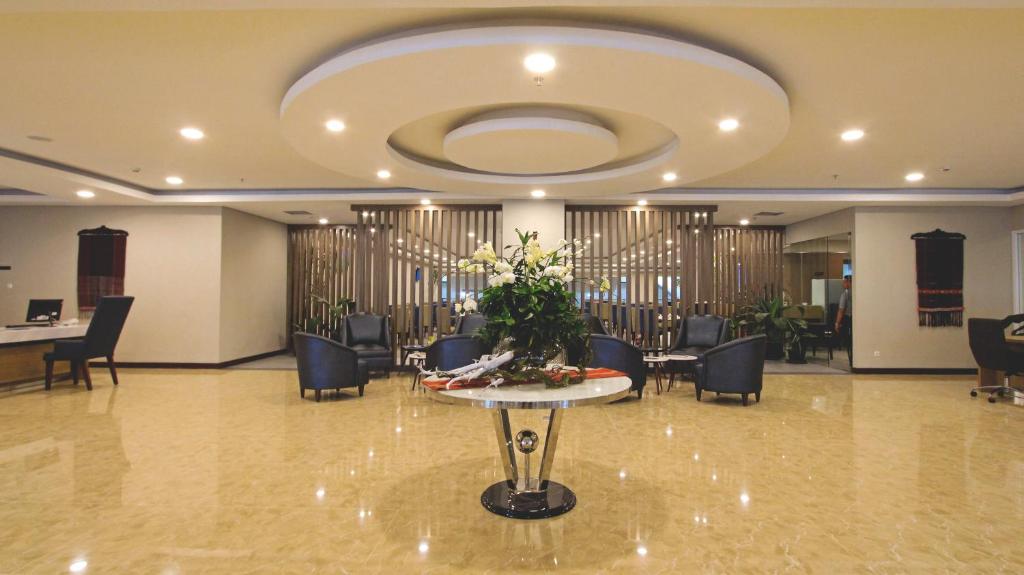 a lobby with a table with flowers on it at Anara Sky Kualanamu Hotel in Medan