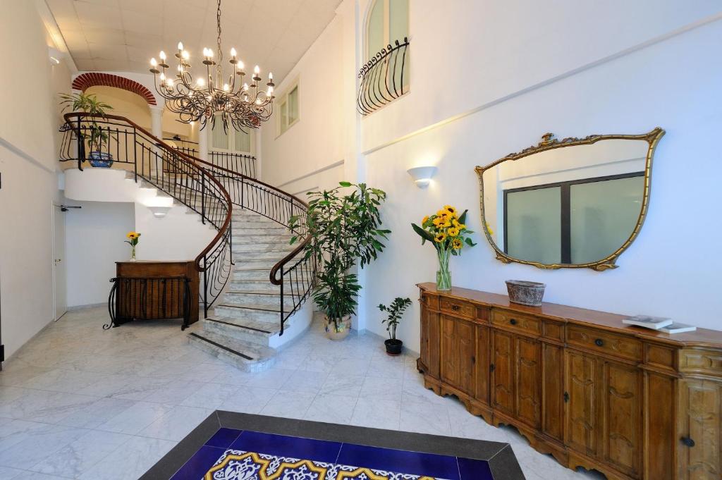 un gran pasillo con escalera y espejo en Aurora Apartments en Amalfi