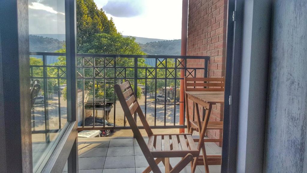 - un balcon avec une table et une chaise dans l'établissement Your Home in Tbilisi: Cosy stay in the Old City, à Tbilissi