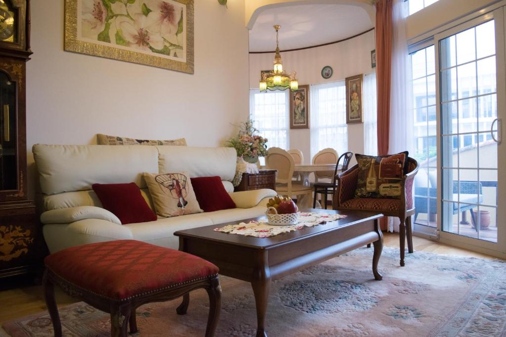 uma sala de estar com um sofá e uma mesa de centro em La Fata em Uruma