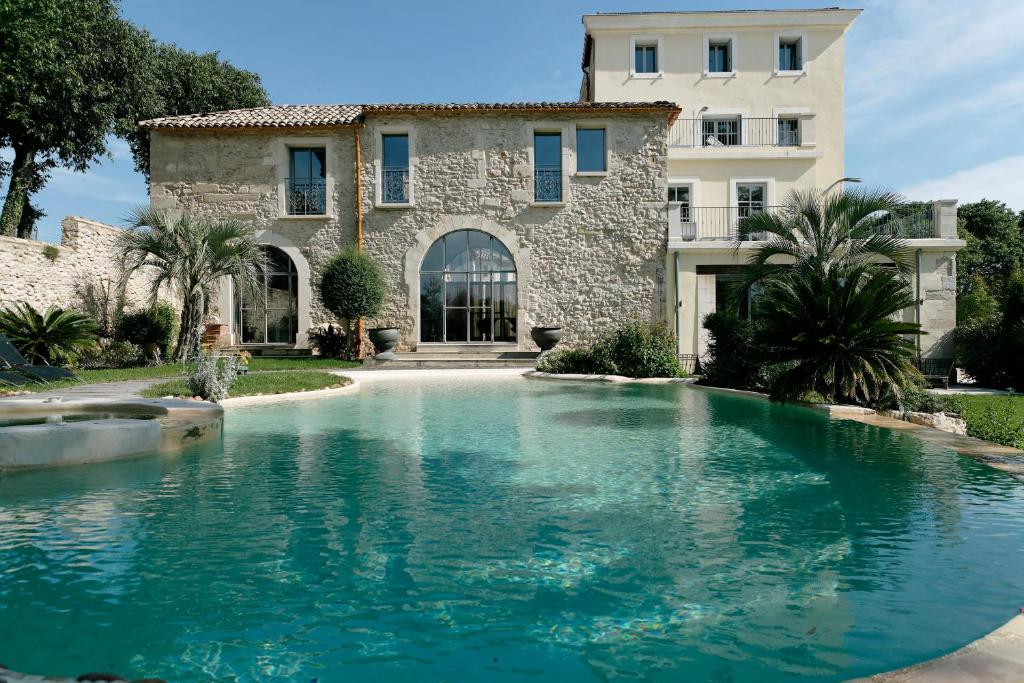 une grande piscine en face d'un bâtiment dans l'établissement Domaine de Verchant & Spa - Relais & Châteaux, à Montpellier
