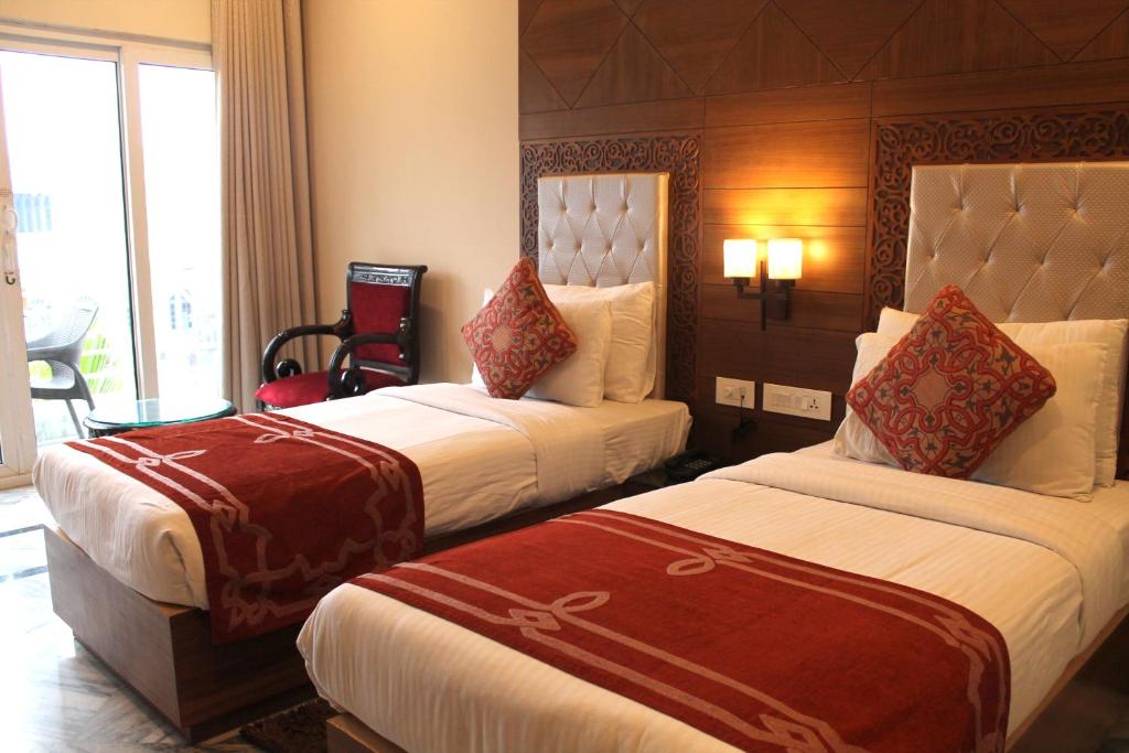 a hotel room with two beds and a window at Hotel Surya, Kaiser Palace in Varanasi