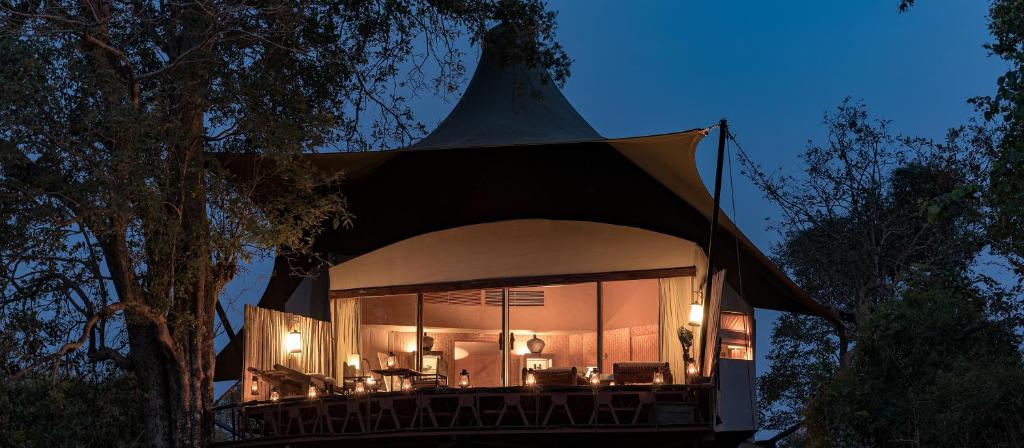 a house with a large tent with tables and chairs at Banjaar Tola Kanha National Park - A Taj Safari Lodge in Kānha