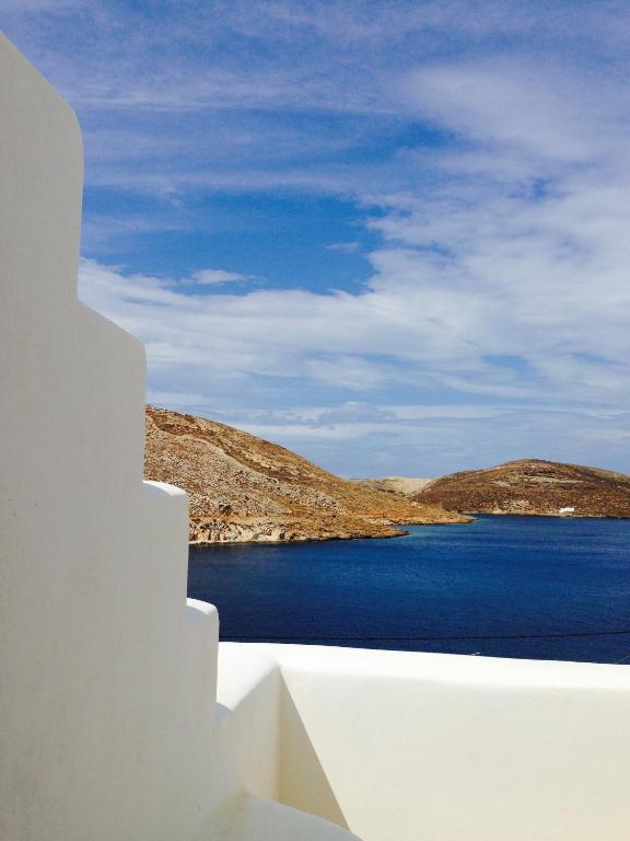 a view of the ocean from a white building at Panormos Art Villas & Suites in Panormos