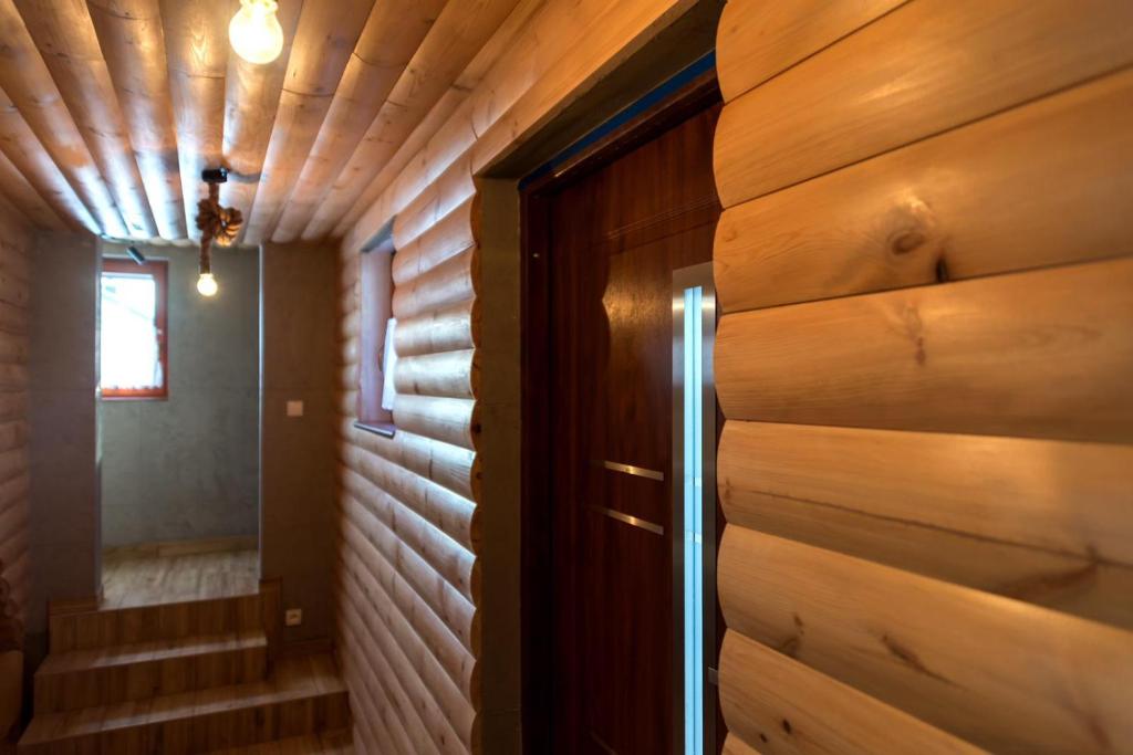 a hallway in a log cabin with a wooden wall at Istebna Pełna chata in Istebna