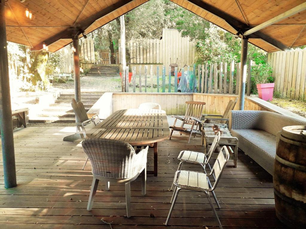 une table et des chaises en bois sur une terrasse en bois dans l'établissement BELLEVUE Maison Atypique Grande Terrasse au Calme, à Pyla-sur-Mer