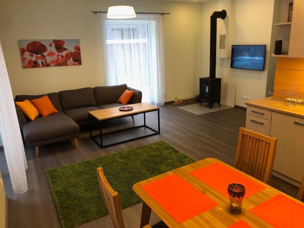 uma sala de estar com um sofá e um fogão em Poilsio apartamentai "Jolita" em Druskininkai
