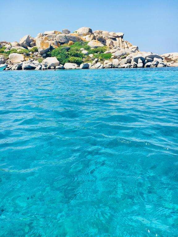 a large body of water with an island in the background at Hotel Les Chambres de Mila Bonifacio in Bonifacio