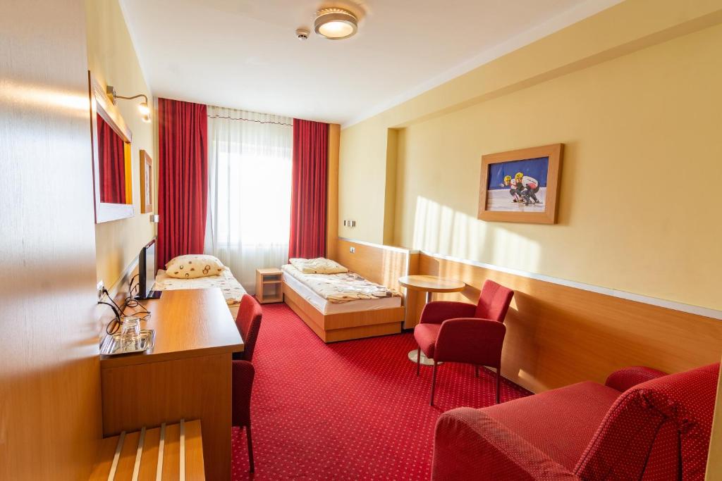 a hotel room with two beds and a red carpet at Dom Sportowca Błonie - MOSiR in Sanok