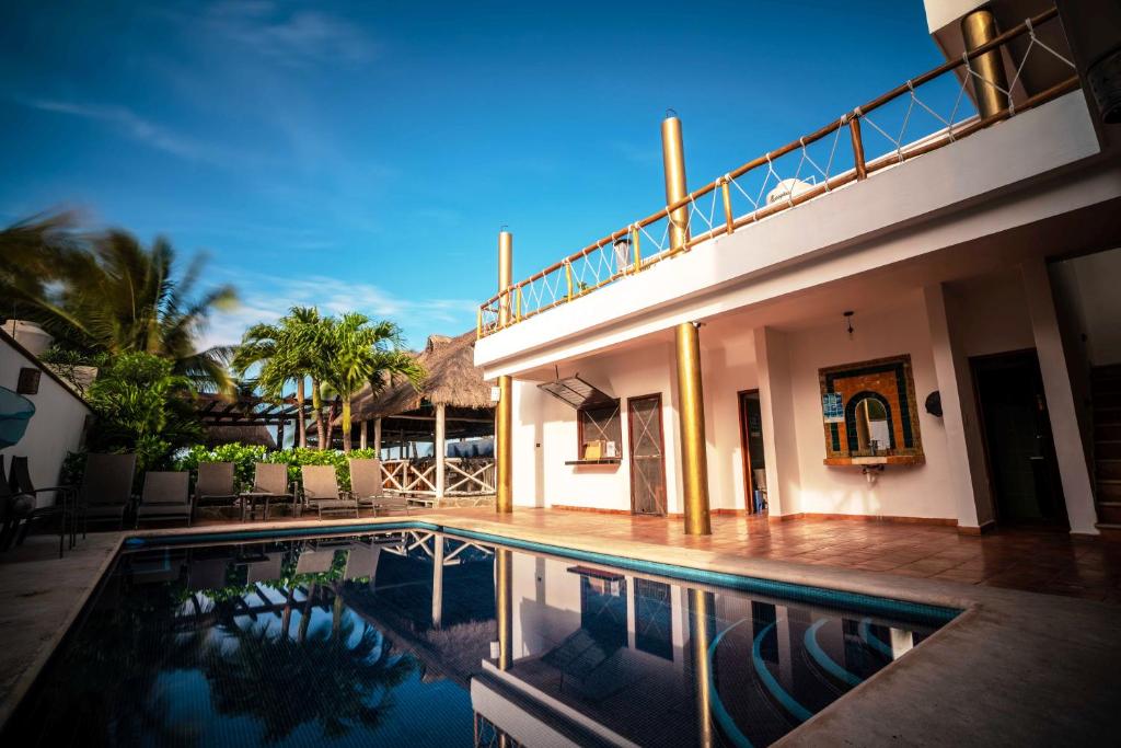 a house with a swimming pool in front of a house at Hotel Boutique Skulls Landing in Isla Mujeres