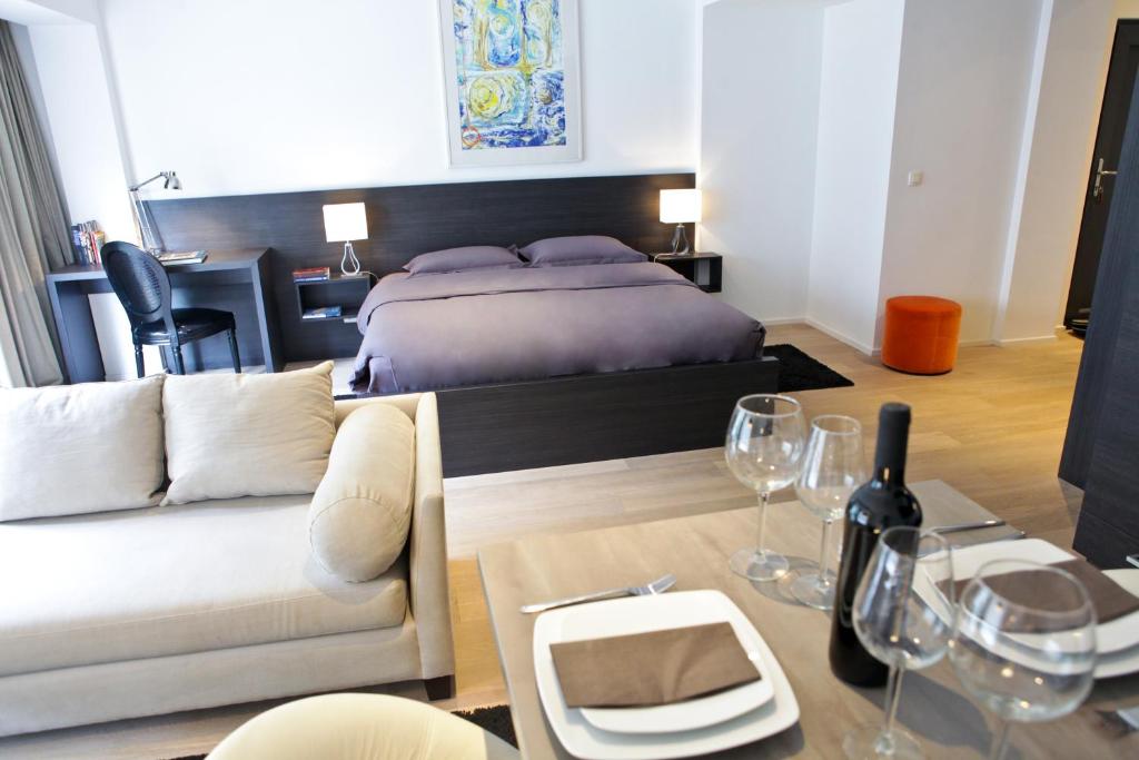 a bedroom with a bed and a couch and a table at Flat Moliere in Brussels