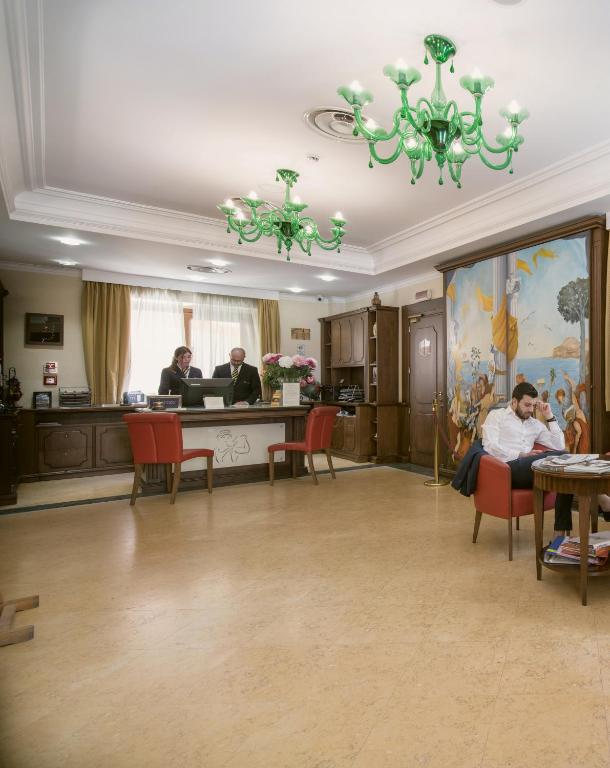 a waiting room with people sitting at a counter at Artemis Hotel in Cefalù