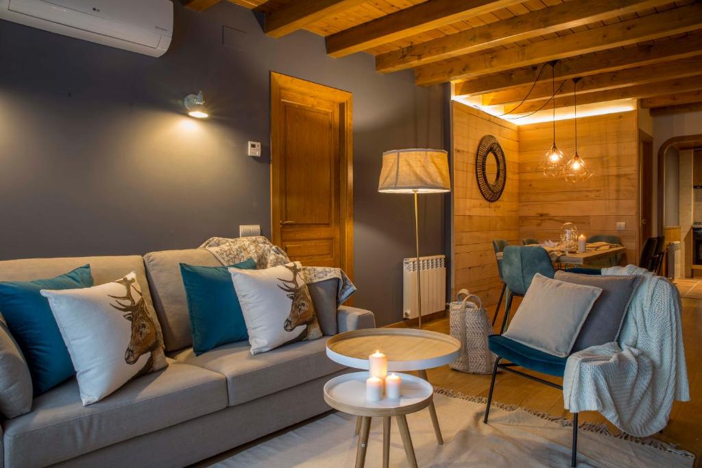 uma sala de estar com um sofá e uma mesa em BARN THE RETREAT Apartamento premium en Esterri em Esterri d'Àneu