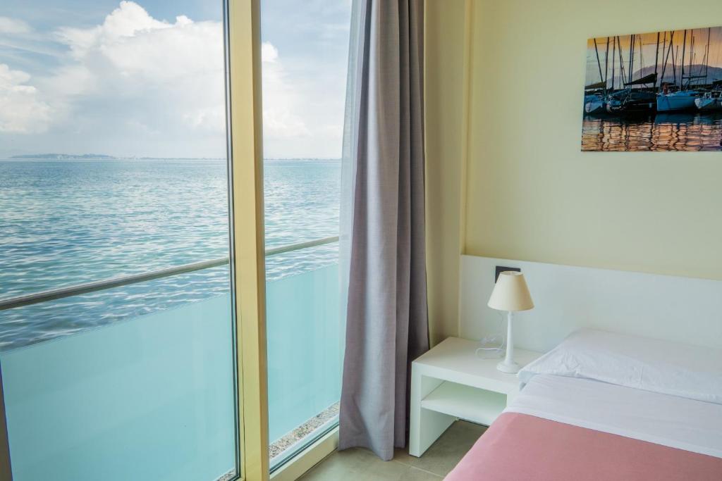 una camera da letto con vista sull'oceano di Garda Rooms a Desenzano del Garda