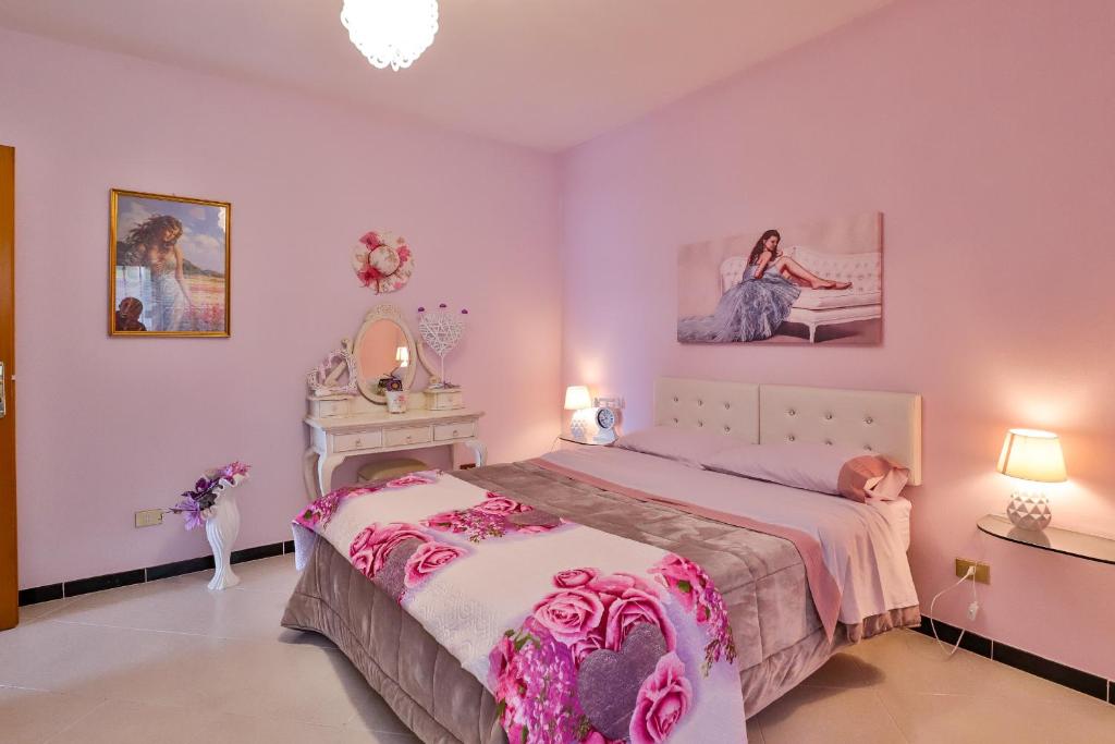 a pink bedroom with a bed and a mirror at B&B Villa luisa in San Mango Piemonte